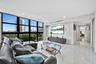 Floor-to-ceiling windows with black framing, polished stone flooring, and recessed ceiling lighting