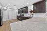 Kitchen featuring dark wood-finish cabinetry, solid-surface countertops, recessed lighting, and wood-finish flooring