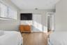 Room featuring wood-finish flooring, white bi-fold closet doors, recessed lighting, and horizontal window blinds