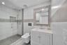 Bright interior featuring large-format tile flooring, expansive floor-to-ceiling windows, custom white built-in cabinetry, and integrated desk workspa