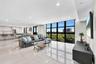Open-concept living space featuring floor-to-ceiling windows with black mullions, large-format polished tile flooring, recessed lighting, and built-in