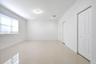Interior room featuring light-toned tile flooring, recessed lighting, horizontal window blinds, and dual-panel closet doors