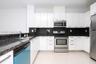 Kitchen featuring white flat-panel cabinetry, dark stone countertops, tile flooring, and a stainless steel appliance suite