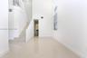 Double-height ceilings featuring an arched window, large-format tile flooring, and a white staircase with a matching balustrade