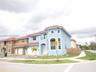 Two-story residence featuring a Mediterranean-inspired exterior, tiled roof, arched entryway, and attached garage