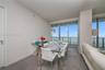Floor-to-ceiling glass windows, recessed ceiling lighting, and large-format tile flooring