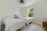 Neutral-toned room featuring large-format tile flooring, a geometric flush-mount ceiling light fixture, and a single-hung window with exterior tree-li