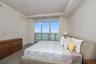 Floor-to-ceiling sliding glass door, recessed ceiling lighting, neutral wall finishes, grey tile flooring, and water backdrop