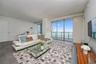 Floor-to-ceiling glass windows, recessed ceiling lighting, and large-format tile flooring
