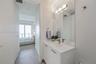 Bathroom featuring a vanity with a white countertop and integrated sink, a full-height wall mirror, modern multi-bulb light fixture, and tile flooring
