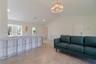 Vaulted ceilings, large-format tile flooring, quartz breakfast bar, and tiered crystal chandelier