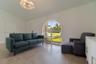 Vaulted ceilings, oversized arched window, large-format tile flooring, and a crystal tiered chandelier