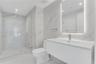 Modern bathroom featuring floor-to-ceiling large-format stone-patterned tile, a glass-enclosed walk-in shower, a white floating vanity with a seamless