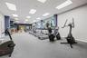 Fitness center featuring recessed lighting, a grid ceiling, carpeted flooring, floor-to-ceiling windows, and mirrored wall surfaces