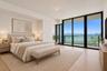 Floor-to-ceiling windows, wood-finish flooring, and black-framed sliding glass doors opening to an exterior balcony