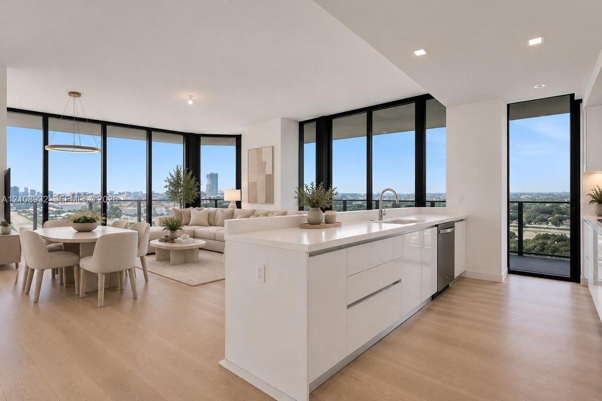 Open-concept living space featuring floor-to-ceiling windows, wood-finish flooring, recessed lighting, and a kitchen island with stone countertops and