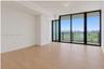 Floor-to-ceiling windows, wood-finish flooring, and access to a balcony with metallic railing