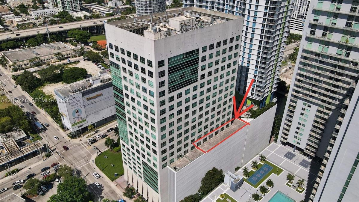 High-rise concrete structure featuring extensive glazing, tiered architectural design, and a multi-level podium