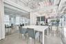 Open-concept interior featuring polished concrete flooring, exposed overhead industrial ductwork, floor-to-ceiling glass wall partitions, and decorati