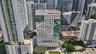 High-rise commercial building featuring a multi-story glass curtain wall, reinforced concrete facade, ground-level professional landscaping, and palm-
