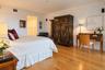 Room featuring wood-finish flooring, smooth-finish walls, and built-in closet cabinetry