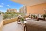 Covered balcony featuring neutral tile flooring, a textured wall finish, and a white metal safety railing