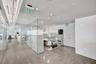 Polished concrete flooring, floor-to-ceiling glass wall partitions, recessed ceiling lighting, and exposed structural ceiling elements