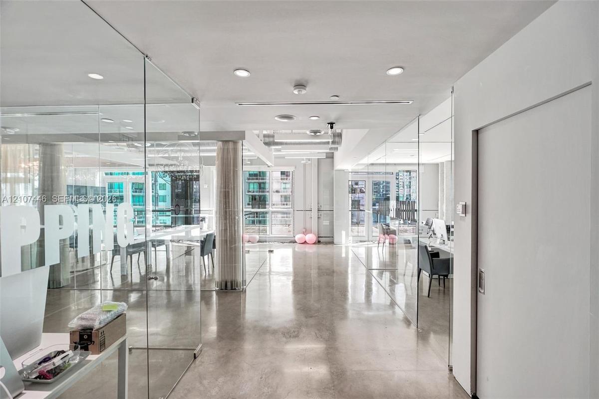Polished concrete flooring, floor-to-ceiling glass partition walls, recessed lighting, and expansive windows