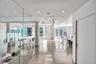 Polished concrete flooring, floor-to-ceiling glass partition walls, recessed lighting, and expansive windows