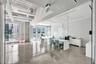 Polished concrete flooring, exposed ceiling ductwork, floor-to-ceiling glass wall partitions, and expansive windows