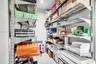 Storage area featuring wall-mounted industrial metal shelving units with adjustable rack positioning and recessed lighting