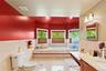 Featuring tile patterned flooring, vanity, a garden tub, plenty of natural light, and tile walls