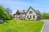 View of front of home with a garage, Belgium Block lined driveway, and a front lawn