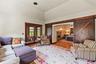 Luxurious Primary Bedroom with a barn door, wood finished floors, arched walkways, and high vaulted ceiling