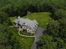 Aerial view of property and surrounding area with a heavily wooded area