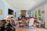 Living area featuring a stone fireplace, light wood-type flooring, recessed lighting, crown molding, and arched walkways
