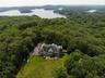 Aerial view of the property with a heavily wooded area and nearby "LAKE MAHOPAC"