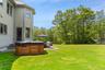 View of grassy yard featuring a hot tub