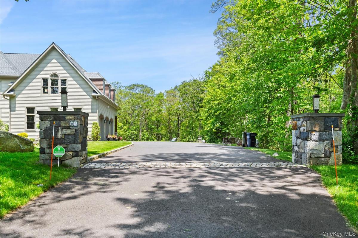 View of stone pillars and expansive driveway