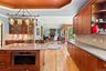 Kitchen featuring ornamental molding, arched walkways, light wood-style floors, recessed lighting, and open shelves