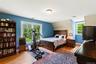 Bedroom featuring wood finished floors, baseboards, and vaulted ceiling