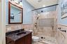 Accessory Apartment full bathroom with tile walls, toilet, vanity, a stall shower, and a gorgeous tiled wainscoted wall