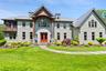 View of front facade featuring a front yard, a shingled roof, and french doors