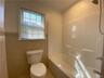 Bathroom with tile patterned floors, shower / washtub combination, tile walls, and toilet