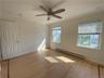 Empty room featuring a baseboard radiator, ceiling fan, light wood-type flooring, and crown molding