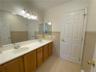 Bathroom with ornamental molding, tile walls, dual bowl vanity, and tile patterned flooring