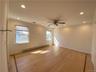 Spare room featuring ceiling fan, baseboard heating, hardwood / wood-style flooring, and ornamental molding
