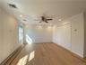 Unfurnished bedroom featuring light hardwood / wood-style flooring, baseboard heating, ceiling fan, and crown molding
