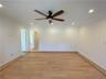 Empty room featuring light wood-type flooring, ceiling fan, and ornamental molding