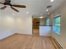Unfurnished living room with baseboard heating, ceiling fan, light wood-type flooring, and crown molding